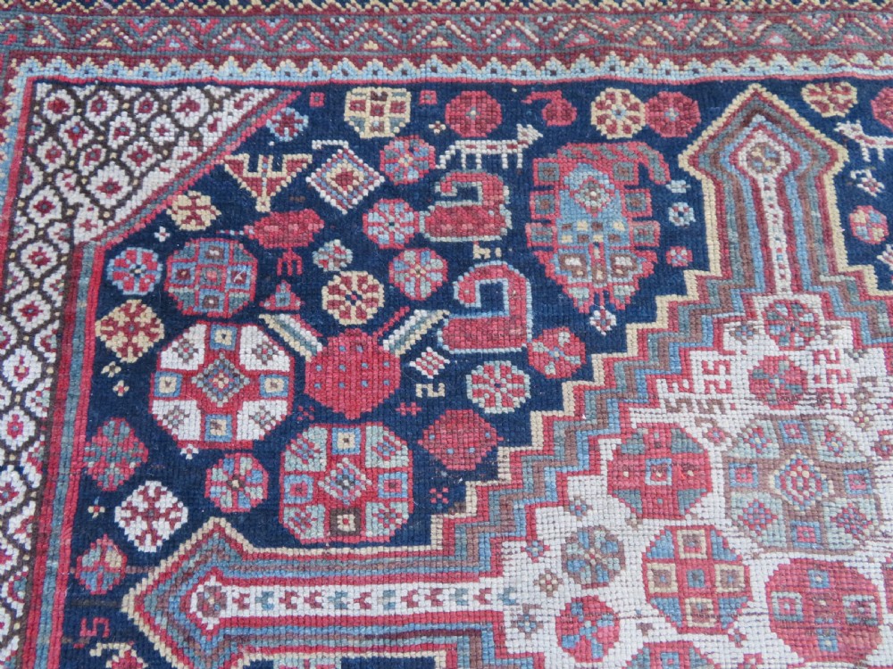 An antique hand-knotted Persian Khamseh carpet featuring three central diamond pole medallions on a dark navy blue field filled with geometric tribal bird and flower motifs surrounded by intricate decorative borders. View XX