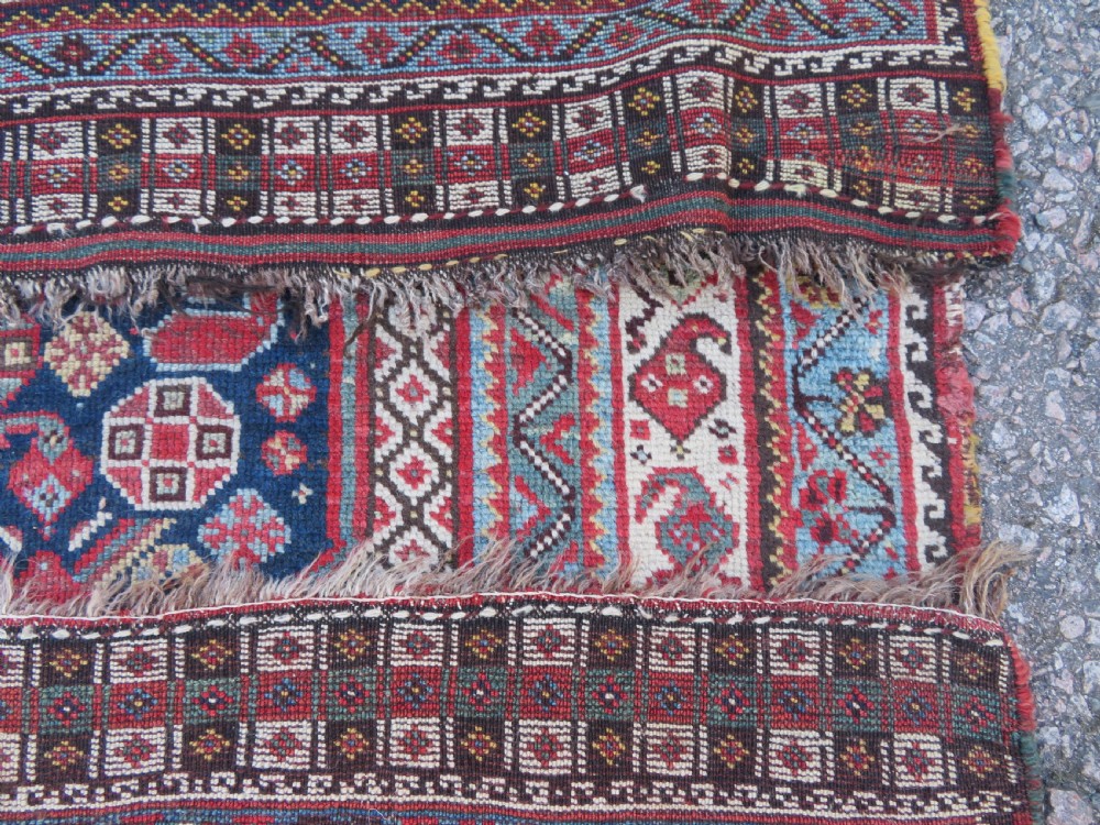 An antique hand-knotted Persian Khamseh carpet featuring three central diamond pole medallions on a dark navy blue field filled with geometric tribal bird and flower motifs surrounded by intricate decorative borders. View XXIV