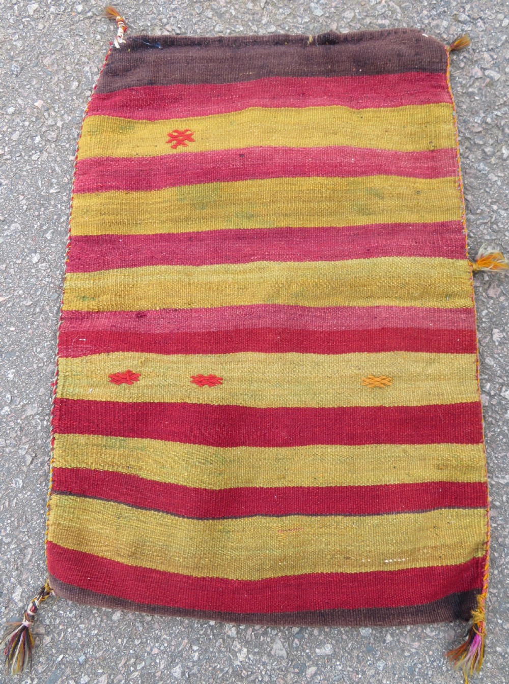 A flatwoven Anatolian kilim grain sack featuring geometric diamond motifs in red, orange, cream, and brown wool with corner tassels. View VIII