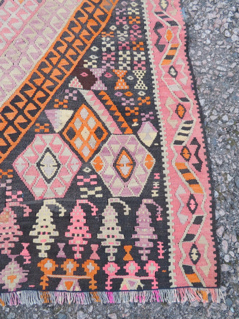 An antique flatwoven Turkish kilim rug featuring central diamond medallions and geometric borders in shades of pink, terracotta, cream, and dark brown. View VII