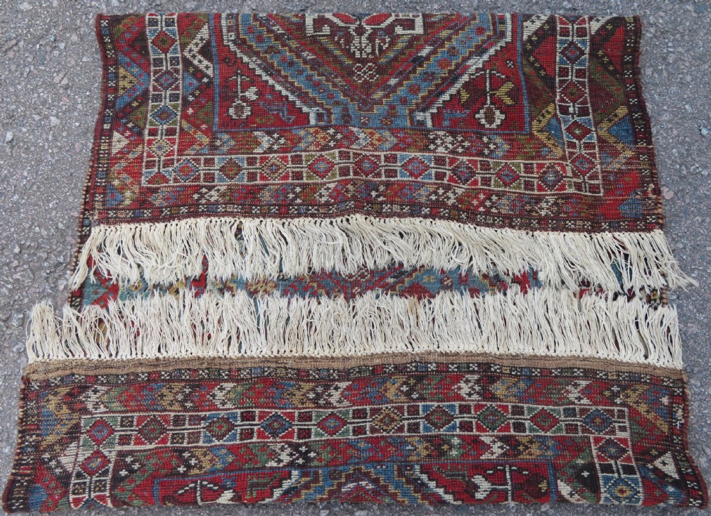 A small hand-knotted wool rug featuring three diamond geometric medallions on a blue and red field surrounded by detailed geometric borders with fringe at the ends. View XIV