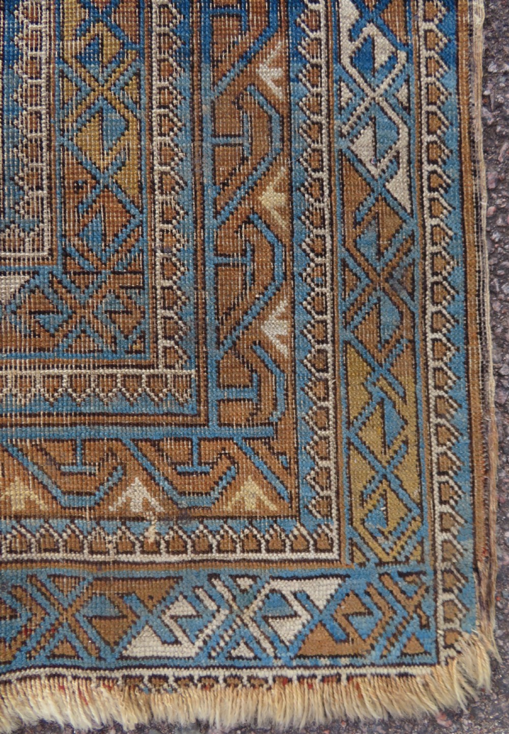 An antique hand-knotted Caucasian Kuba Seichur wool rug featuring a geometric white ground field surrounded by multi-layered patterned borders in blue, terracotta, and ochre. View VIII