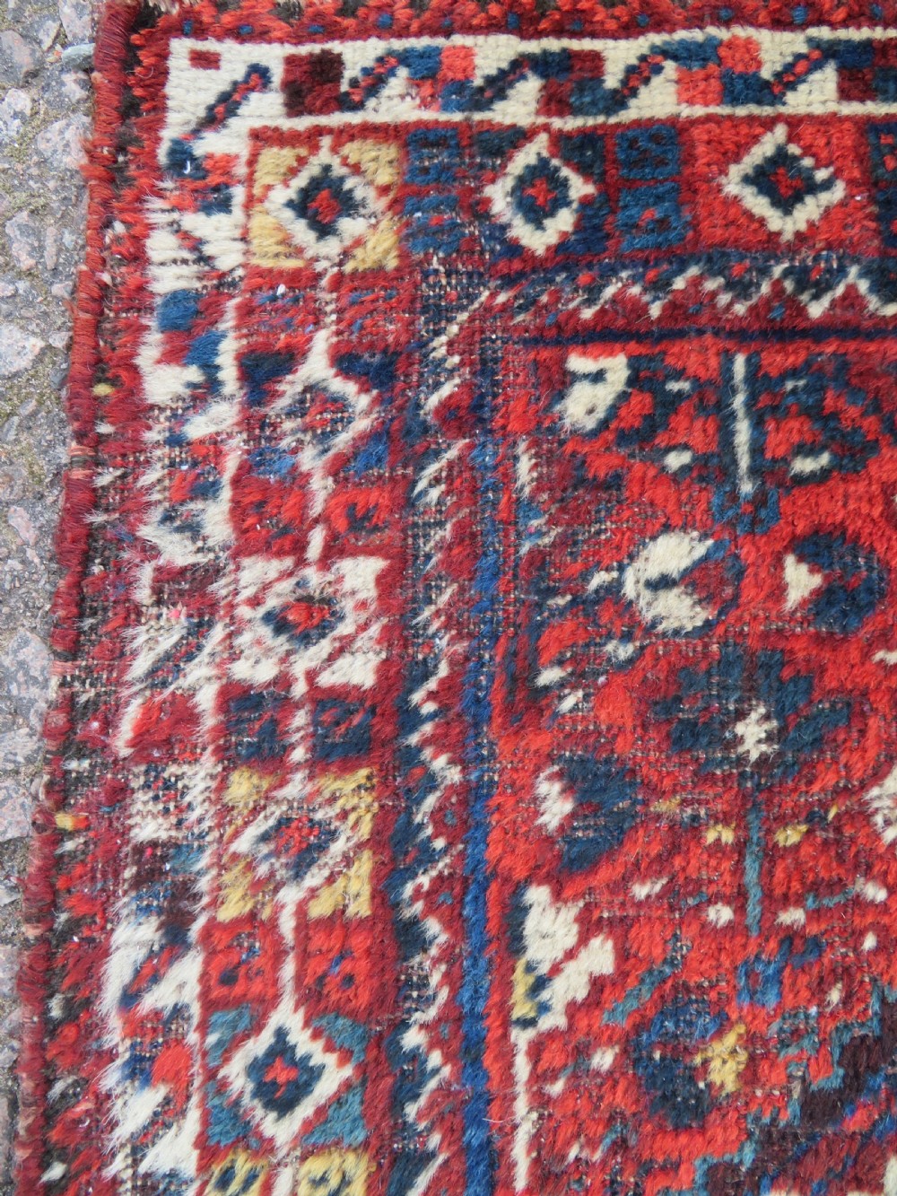 An antique South Persian Khamseh rug featuring three diamond-shaped central medallions and geometric bird motifs in shades of red, navy blue, and cream. View VII