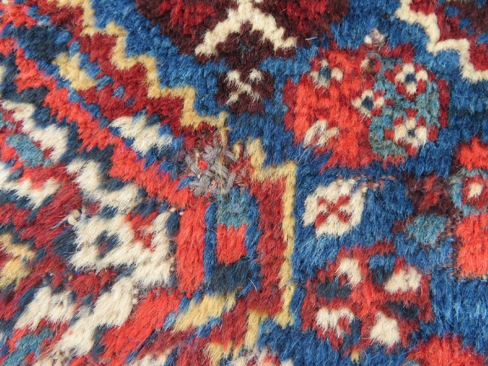 An antique South Persian Khamseh rug featuring three diamond-shaped central medallions and geometric bird motifs in shades of red, navy blue, and cream. View VIII