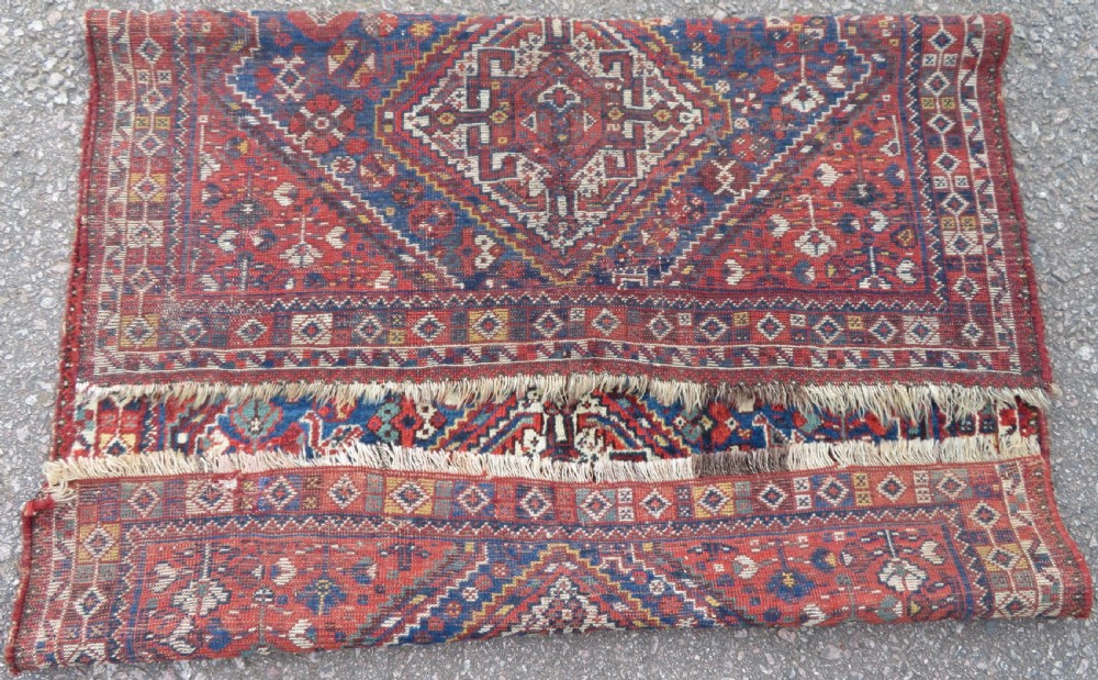 An antique South Persian Khamseh rug featuring three diamond-shaped central medallions and geometric bird motifs in shades of red, navy blue, and cream. View XIII