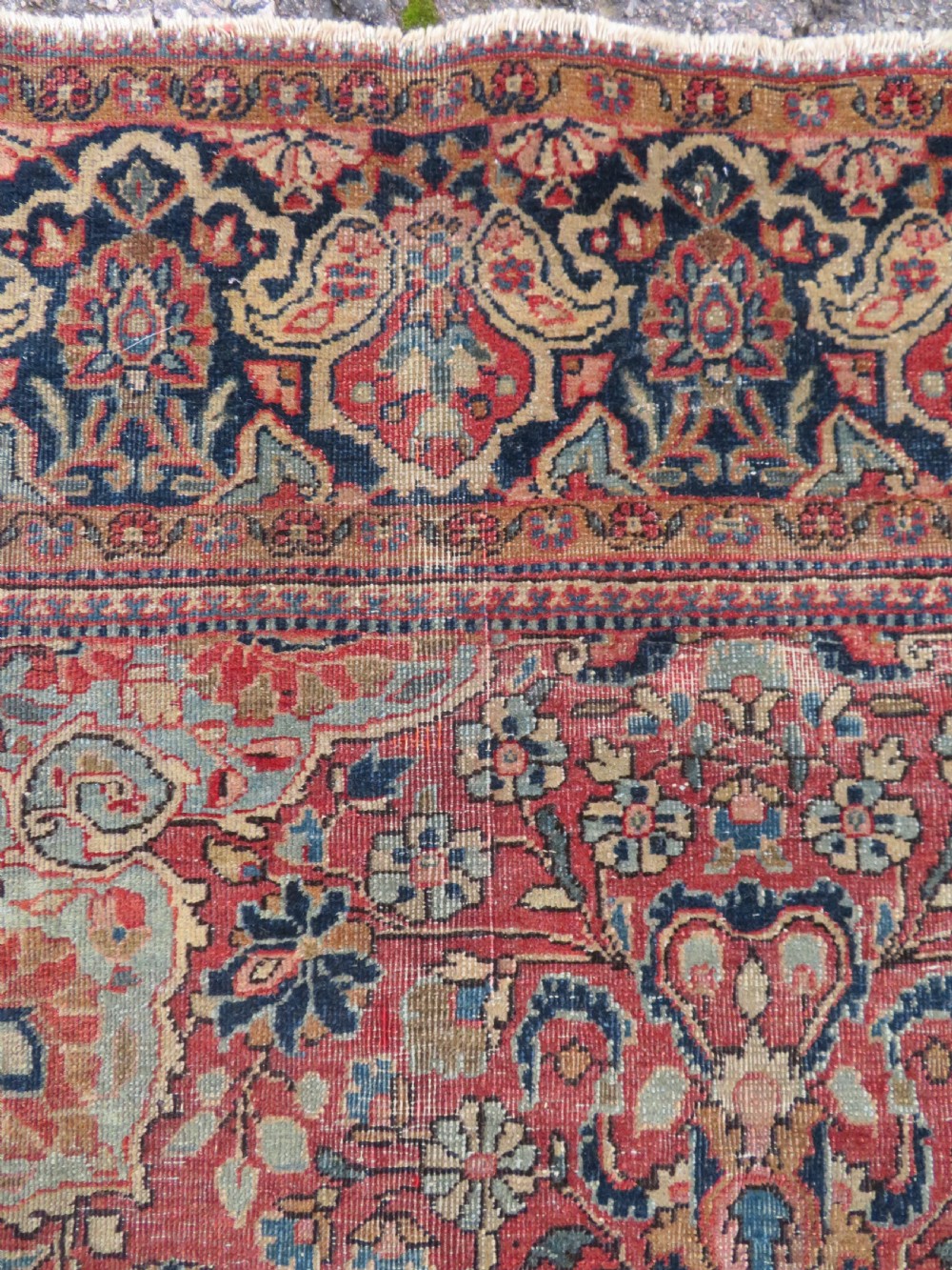 A rectangular hand-knotted wool Kashan rug featuring a central starburst medallion surrounded by dense floral patterns on a terracotta field with a navy border. View VII