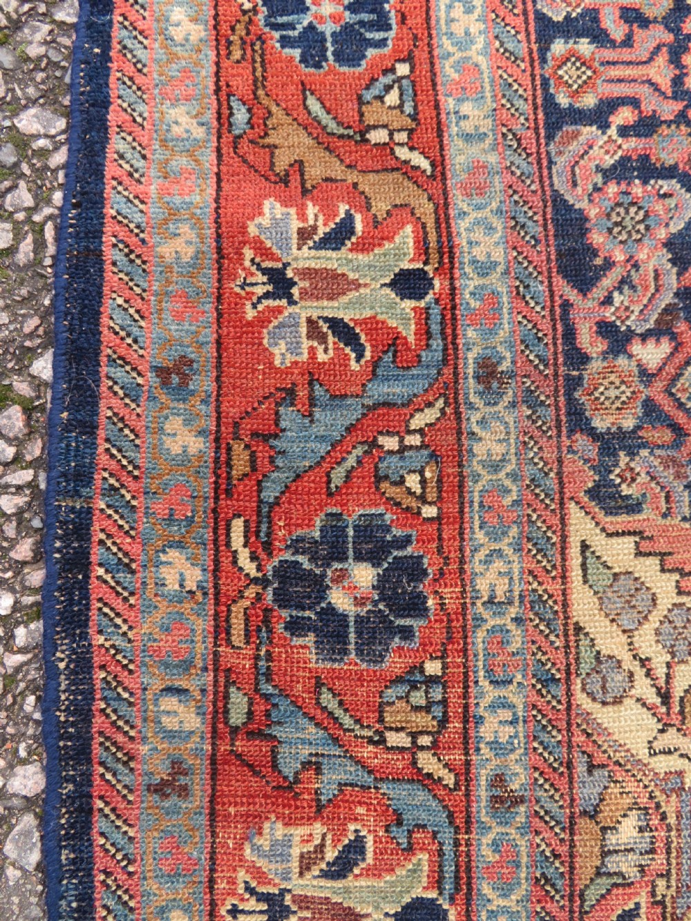 A rectangular antique Persian Malayer wool rug with a central cream and red medallion set against a dark navy field surrounded by intricate floral borders. View IX