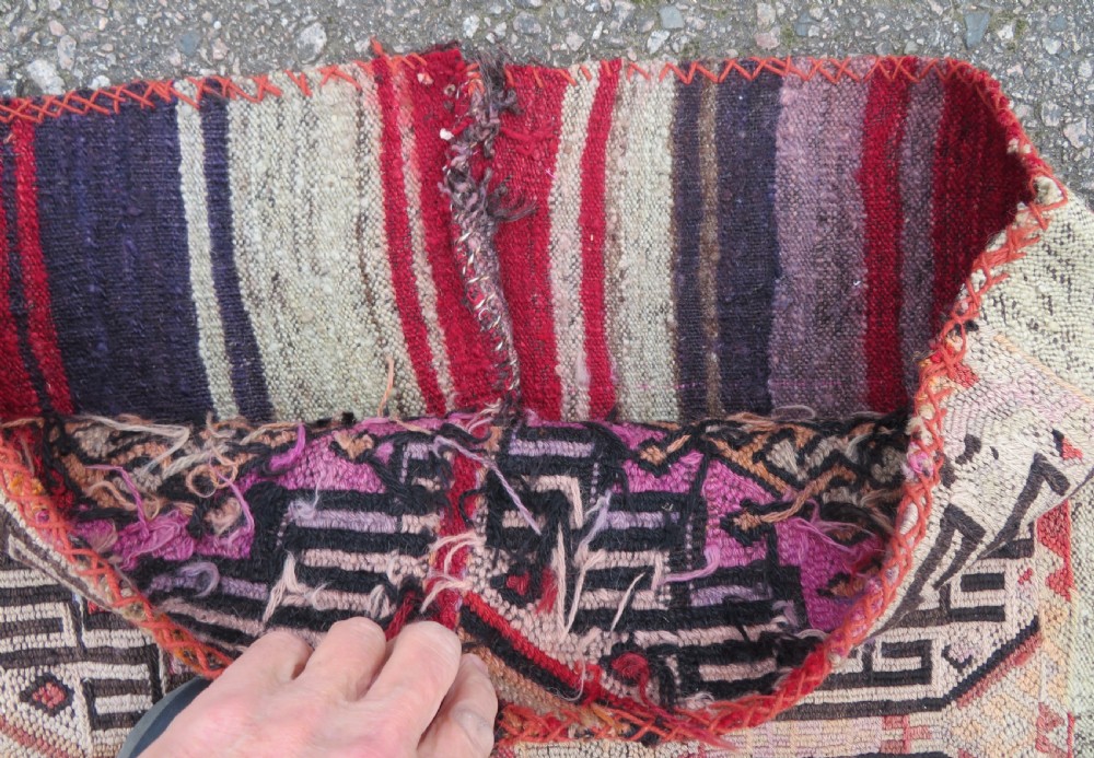 A group of four individual hand-woven Turkish kilim mats featuring vibrant geometric patterns, diamond medallions, and zig-zag borders. View IV