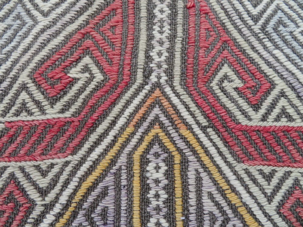 A group of four individual hand-woven Turkish kilim mats featuring vibrant geometric patterns, diamond medallions, and zig-zag borders. View X