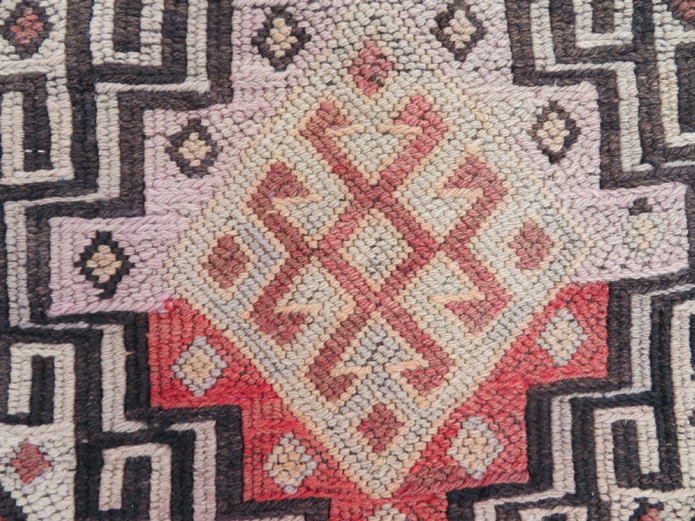 A group of four individual hand-woven Turkish kilim mats featuring vibrant geometric patterns, diamond medallions, and zig-zag borders. View XI