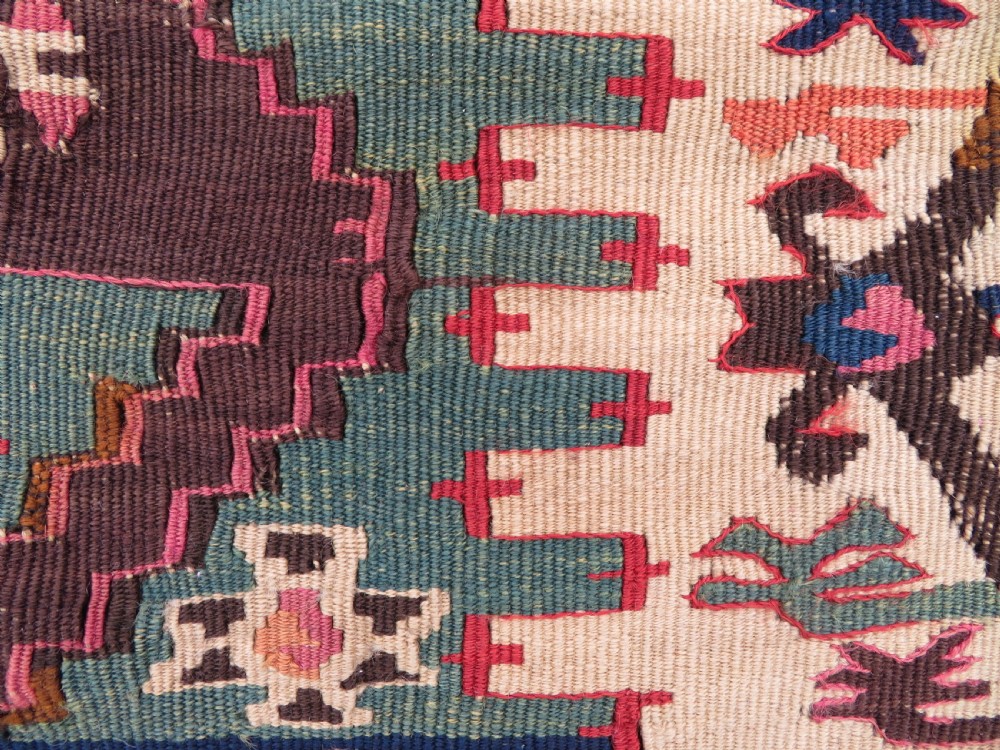 A group of four individual hand-woven Turkish kilim mats featuring vibrant geometric patterns, diamond medallions, and zig-zag borders. View XII