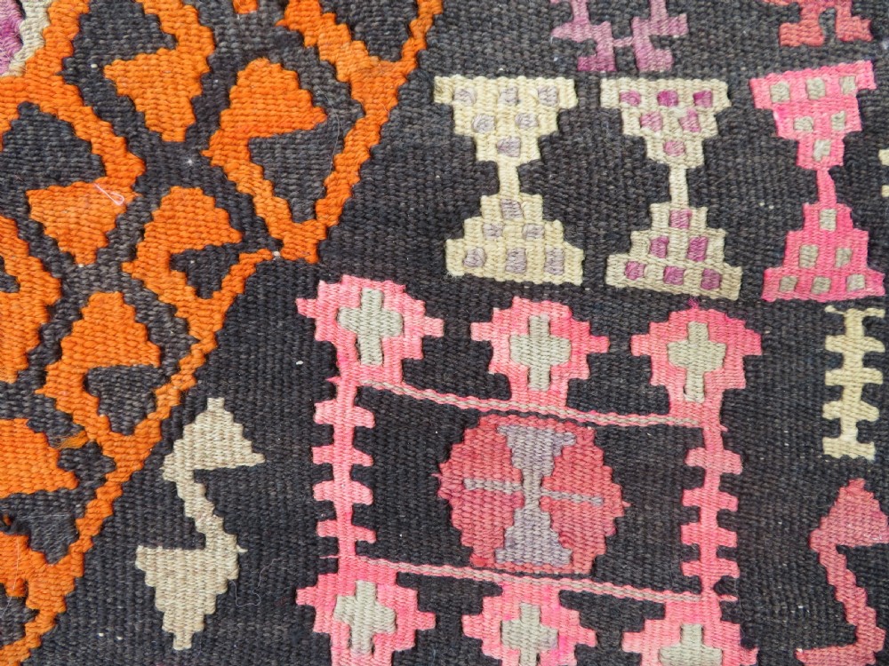 A group of four individual hand-woven Turkish kilim mats featuring vibrant geometric patterns, diamond medallions, and zig-zag borders. View XIII