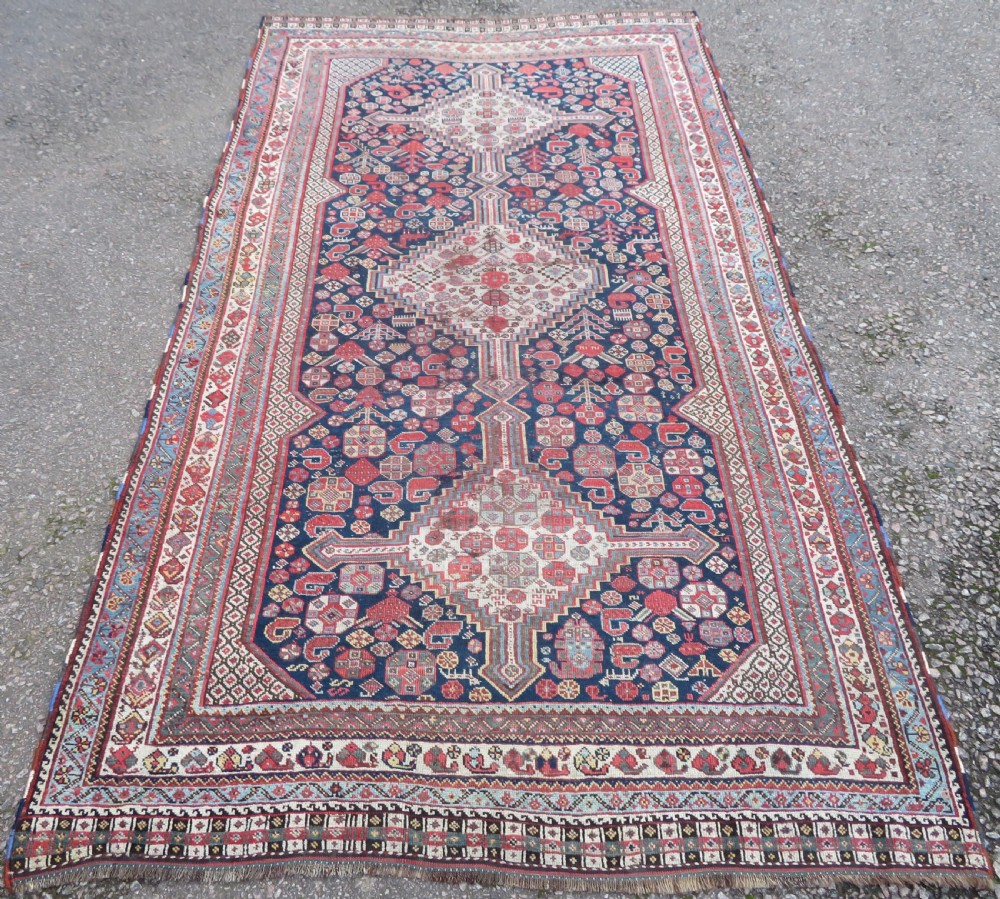 An antique hand-knotted Khamseh tribal wool rug featuring three geometric pole medallions in navy blue, terracotta red, and cream with detailed borders. View II