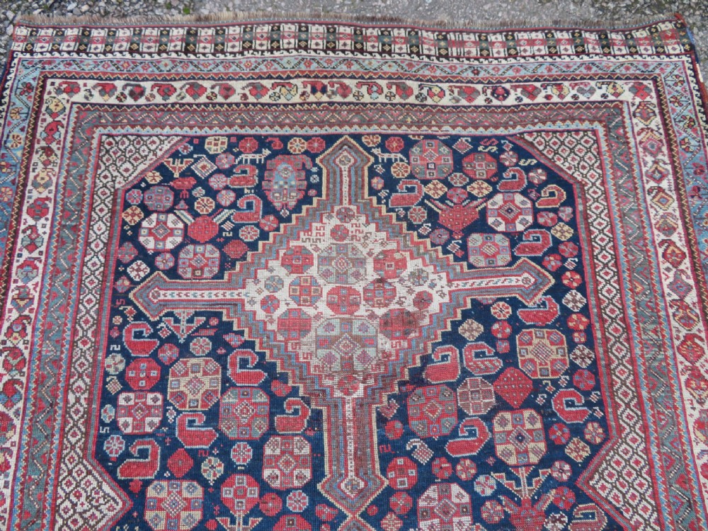 An antique hand-knotted Khamseh tribal wool rug featuring three geometric pole medallions in navy blue, terracotta red, and cream with detailed borders. View V