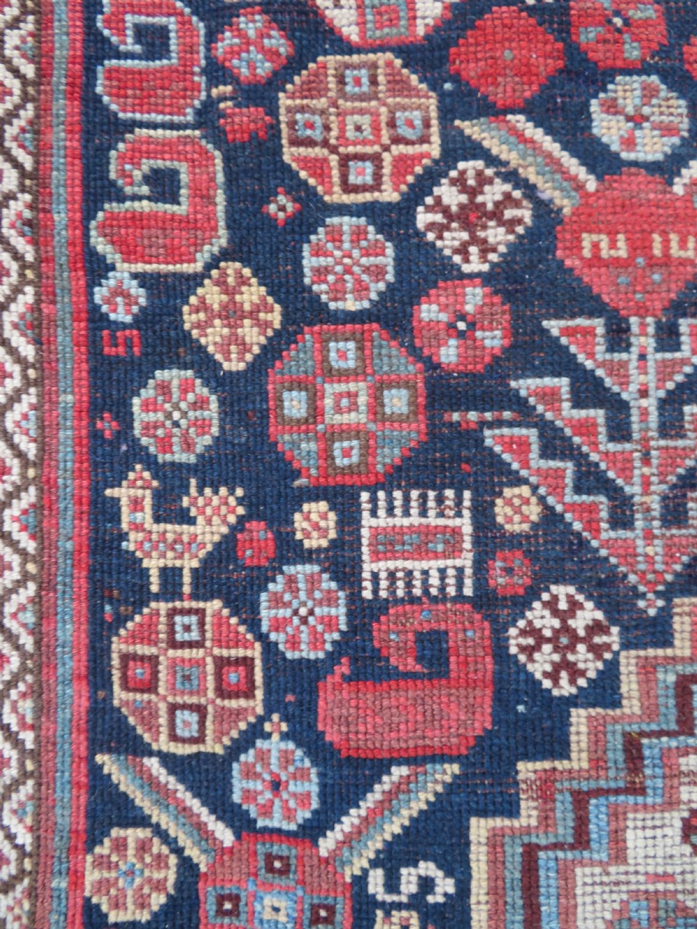 An antique hand-knotted Khamseh tribal wool rug featuring three geometric pole medallions in navy blue, terracotta red, and cream with detailed borders. View X