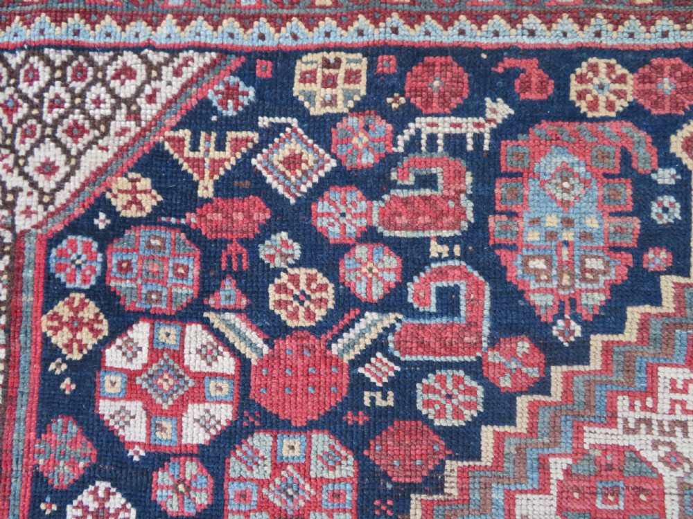 An antique hand-knotted Khamseh tribal wool rug featuring three geometric pole medallions in navy blue, terracotta red, and cream with detailed borders. View XV