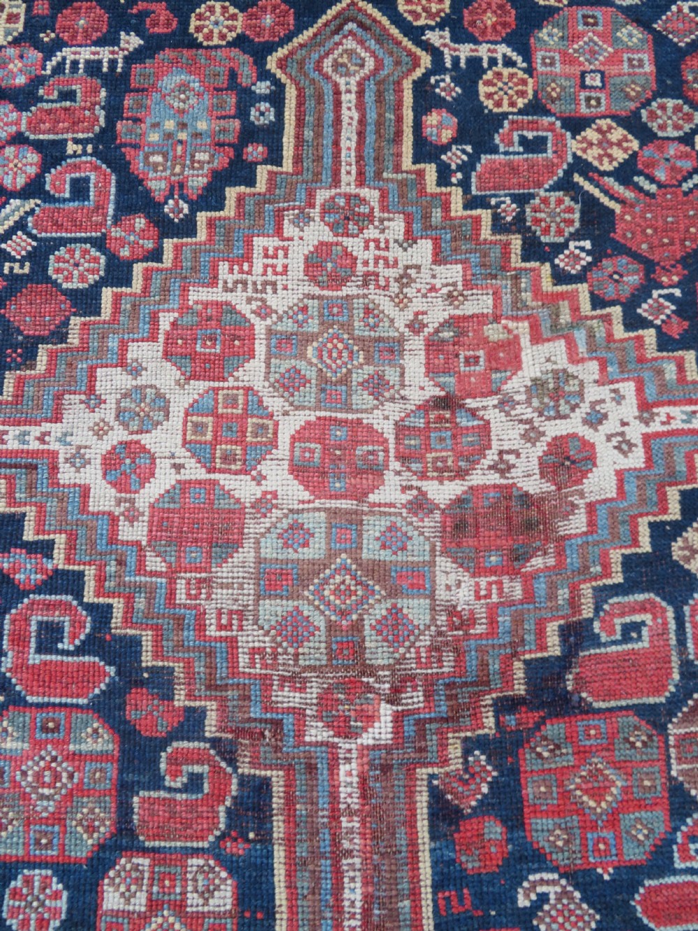 An antique hand-knotted Khamseh tribal wool rug featuring three geometric pole medallions in navy blue, terracotta red, and cream with detailed borders. View XVI