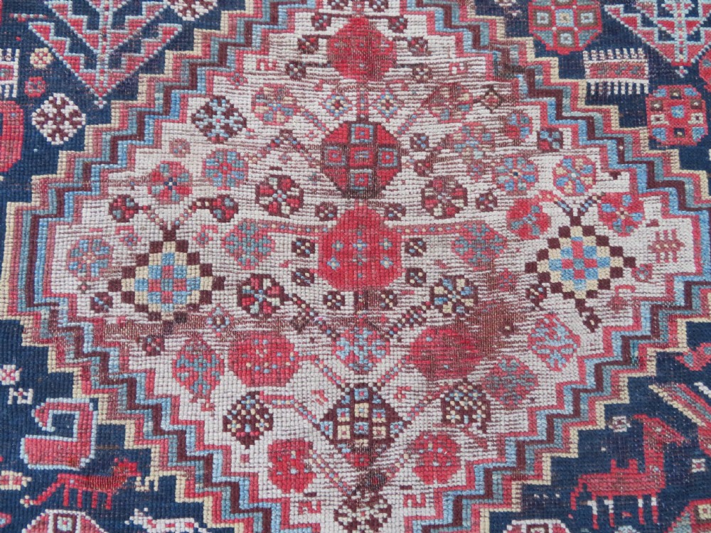 An antique hand-knotted Khamseh tribal wool rug featuring three geometric pole medallions in navy blue, terracotta red, and cream with detailed borders. View XVII