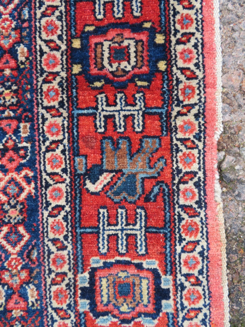 An antique West Persian Senneh wool rug featuring a navy blue stepped diamond medallion centered on a terracotta red field with intricate geometric borders. View XII
