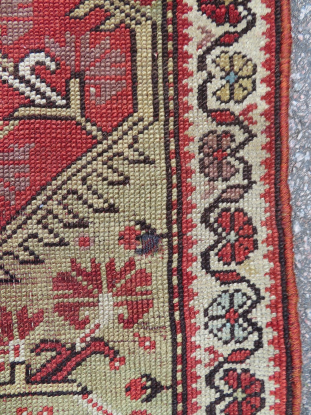 An antique handwoven Anatolian Ada Melas wool rug featuring central geometric medallions in grey, red, and ochre framed by detailed botanical borders. View VIII