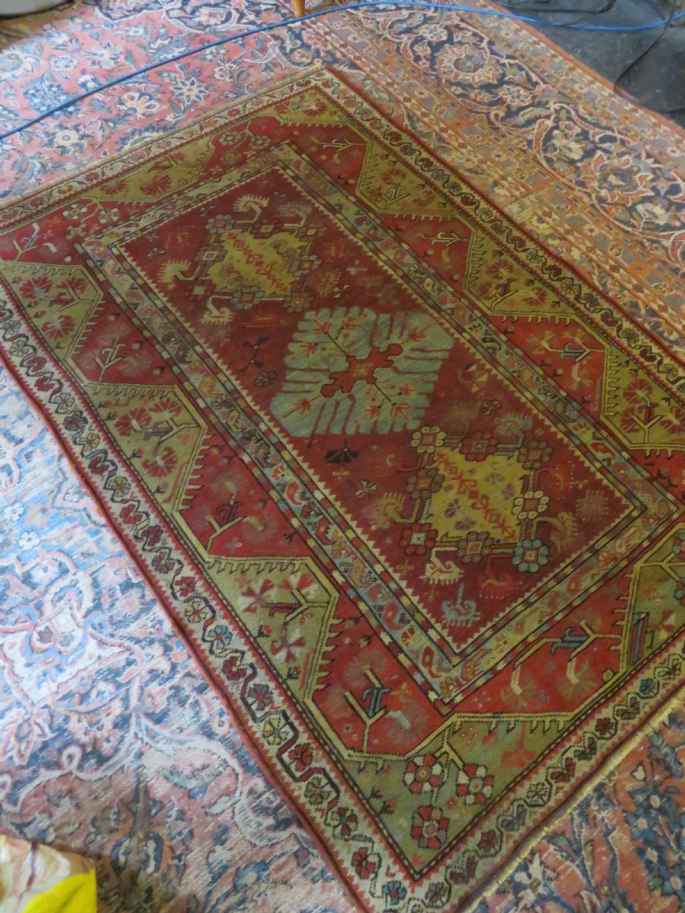 An antique handwoven Anatolian Ada Melas wool rug featuring central geometric medallions in grey, red, and ochre framed by detailed botanical borders. View XXII