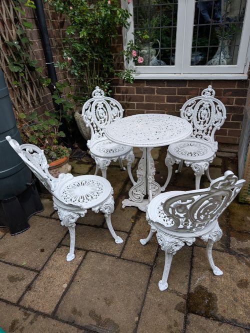 SUPERB SET OF FOUR CASTIRON GARDEN CHAIRS TOGETHER WITH RARE CHRISTOPHER DRESSER DESIGN TABLE