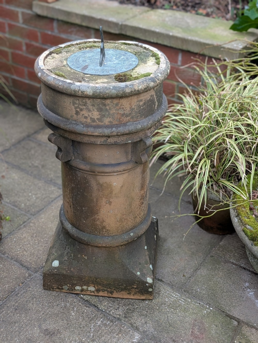 A nineteenth-century Victorian terracotta chimney pot repurposed as a garden sundial with a circular lead dial and gnomon. View II