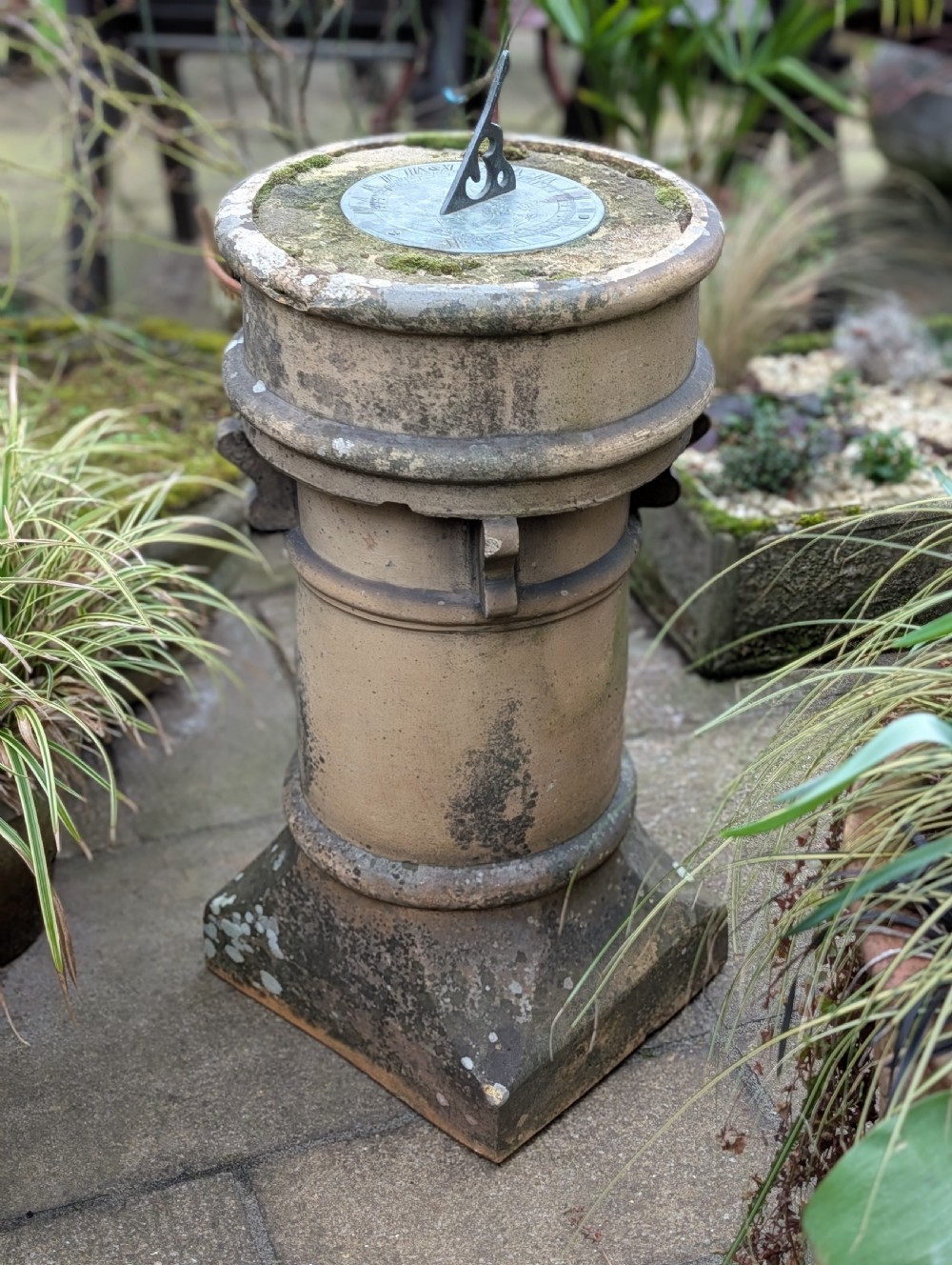 A nineteenth-century Victorian terracotta chimney pot repurposed as a garden sundial with a circular lead dial and gnomon. View V