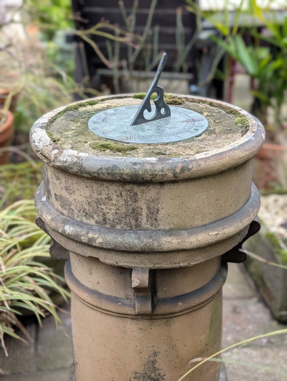 A nineteenth-century Victorian terracotta chimney pot repurposed as a garden sundial with a circular lead dial and gnomon. View VI