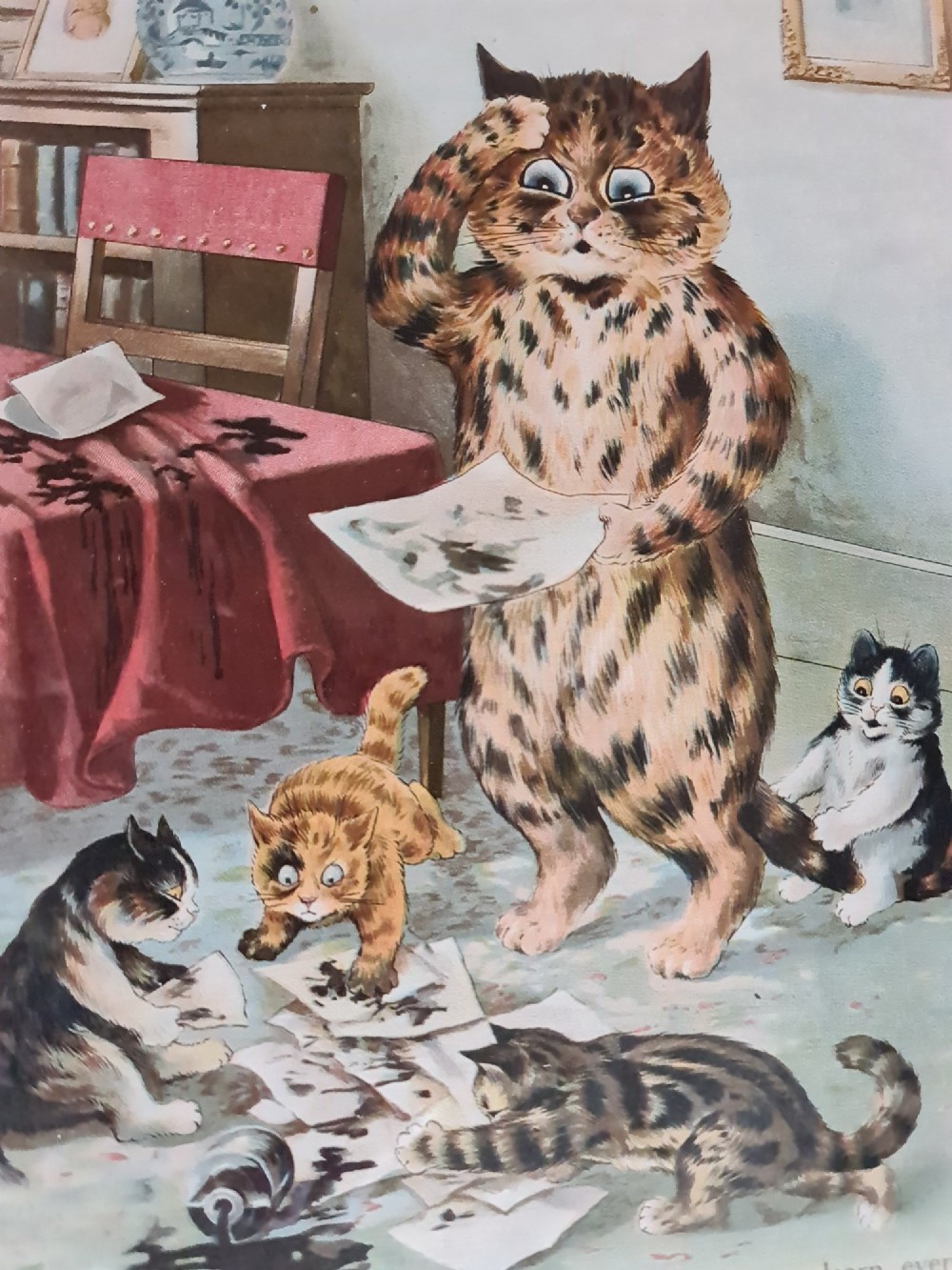 A pair of black framed antique prints depicting anthropomorphic cats in domestic interior scenes with printed text captions. View III