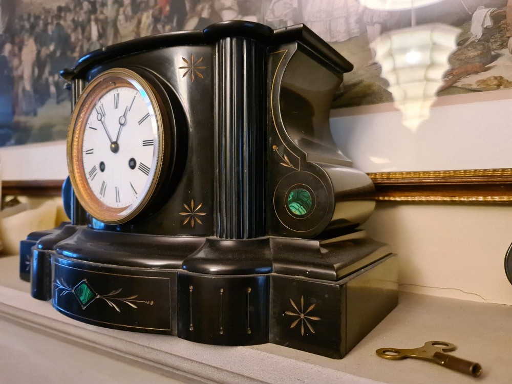 A Victorian black slate mantel clock featuring incised gilt star motifs, green malachite stone inlays, twin fluted columns, and a white enamel dial with Roman numerals. View II