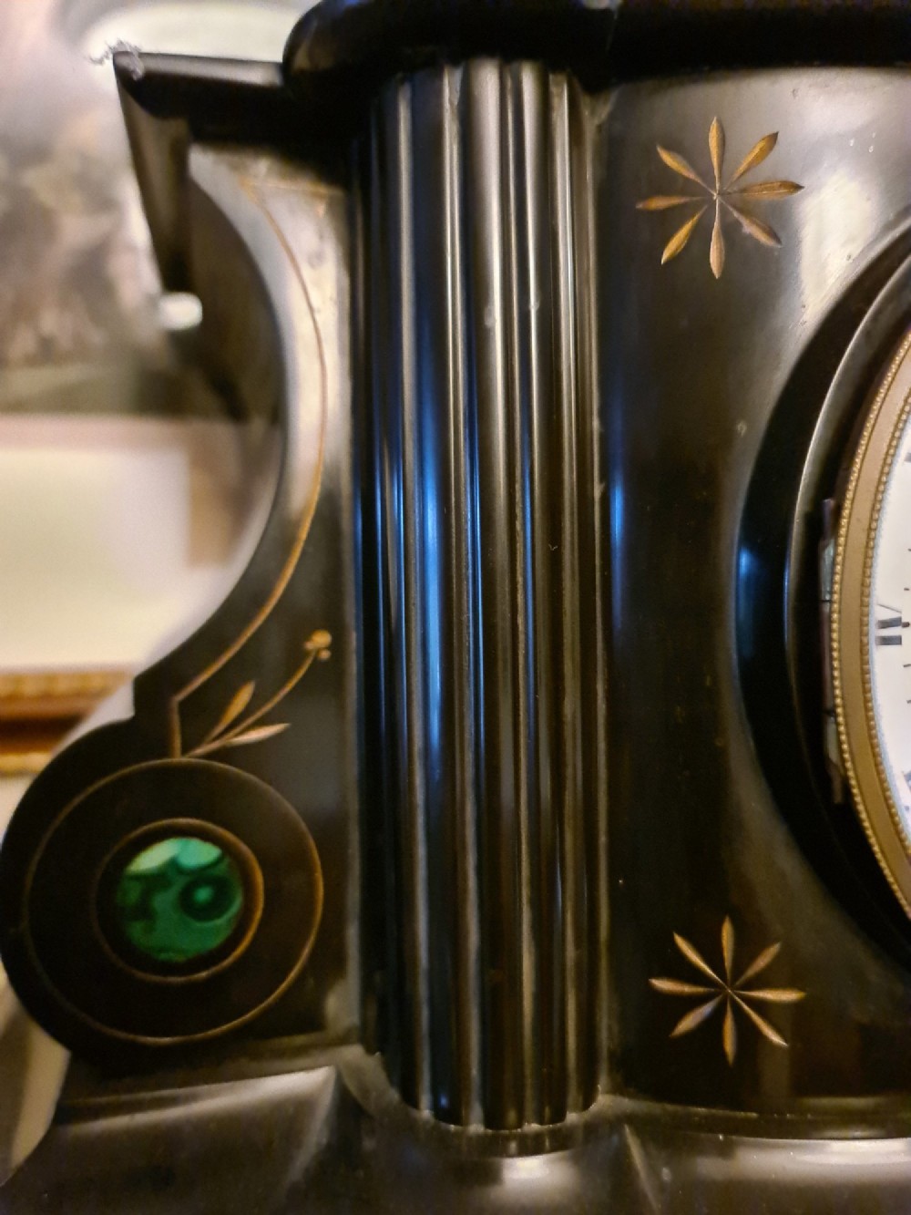 A Victorian black slate mantel clock featuring incised gilt star motifs, green malachite stone inlays, twin fluted columns, and a white enamel dial with Roman numerals. View V