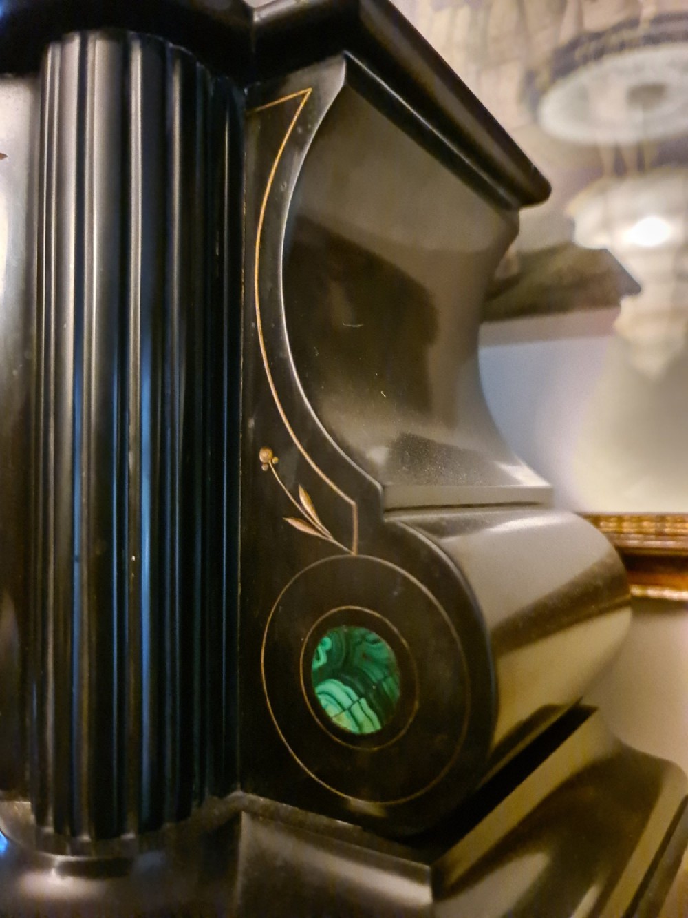 A Victorian black slate mantel clock featuring incised gilt star motifs, green malachite stone inlays, twin fluted columns, and a white enamel dial with Roman numerals. View VI