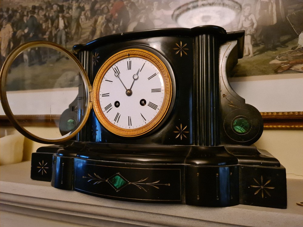 A Victorian black slate mantel clock featuring incised gilt star motifs, green malachite stone inlays, twin fluted columns, and a white enamel dial with Roman numerals. View VII