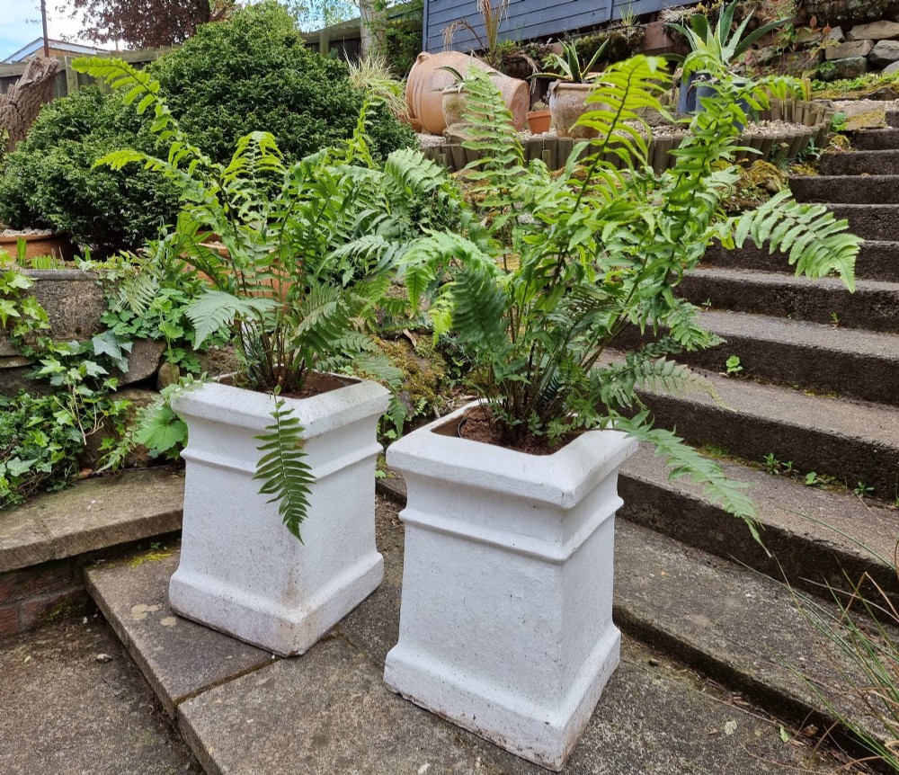 A pair of 19th-century square white-painted terracotta chimney pot pedestals with moulded rims resting on stone steps. View III