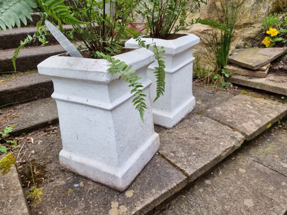 A pair of 19th-century square white-painted terracotta chimney pot pedestals with moulded rims resting on stone steps. View IV