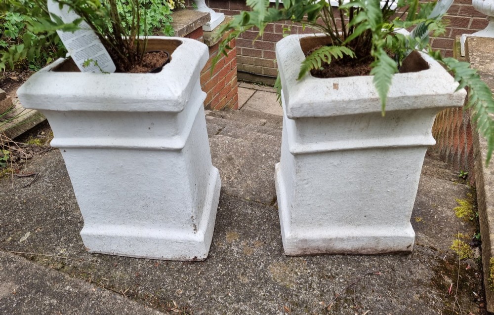 A pair of 19th-century square white-painted terracotta chimney pot pedestals with moulded rims resting on stone steps. View V