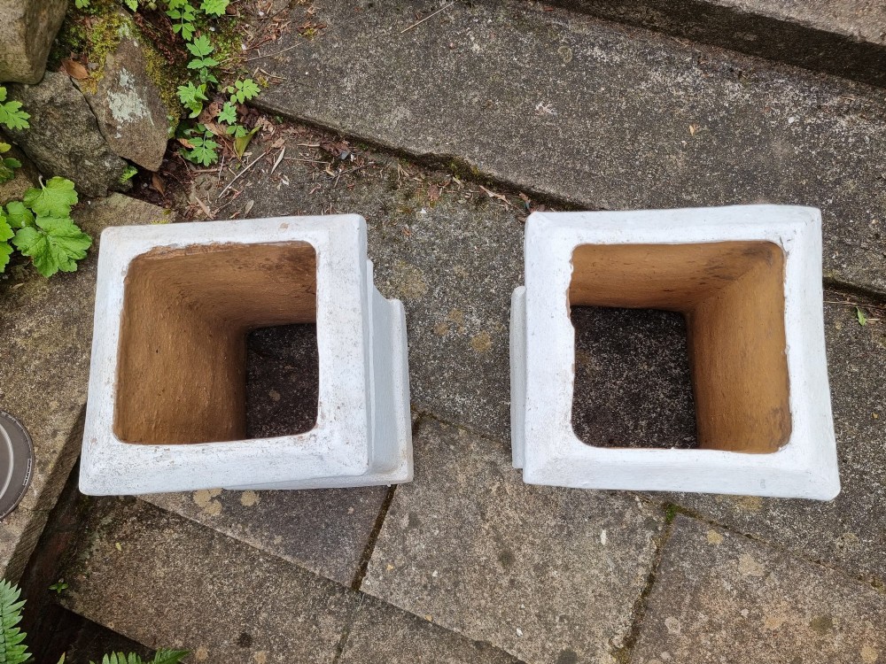 A pair of 19th-century square white-painted terracotta chimney pot pedestals with moulded rims resting on stone steps. View VI