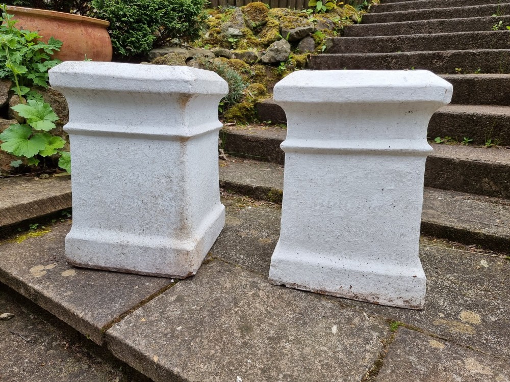 A pair of 19th-century square white-painted terracotta chimney pot pedestals with moulded rims resting on stone steps.