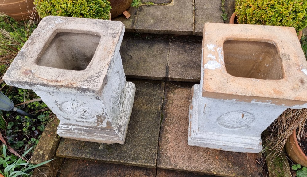 A pair of square weathered terracotta garden pedestals featuring moulded top rims and central circular floral medallion motifs. View II