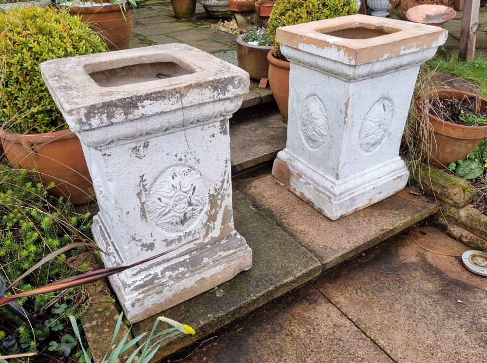 A pair of square weathered terracotta garden pedestals featuring moulded top rims and central circular floral medallion motifs. View III