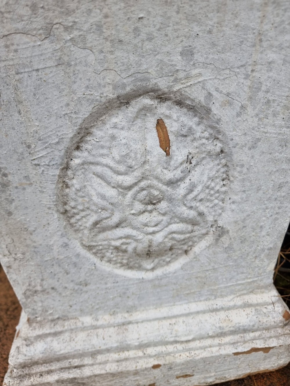 A pair of square weathered terracotta garden pedestals featuring moulded top rims and central circular floral medallion motifs. View V