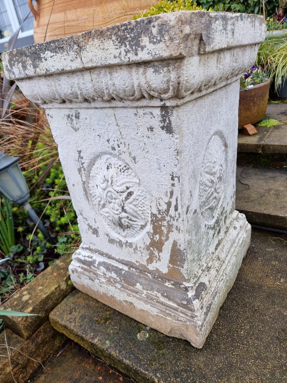 A pair of square weathered terracotta garden pedestals featuring moulded top rims and central circular floral medallion motifs. View VI