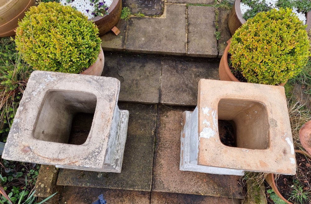 A pair of square weathered terracotta garden pedestals featuring moulded top rims and central circular floral medallion motifs. View VII