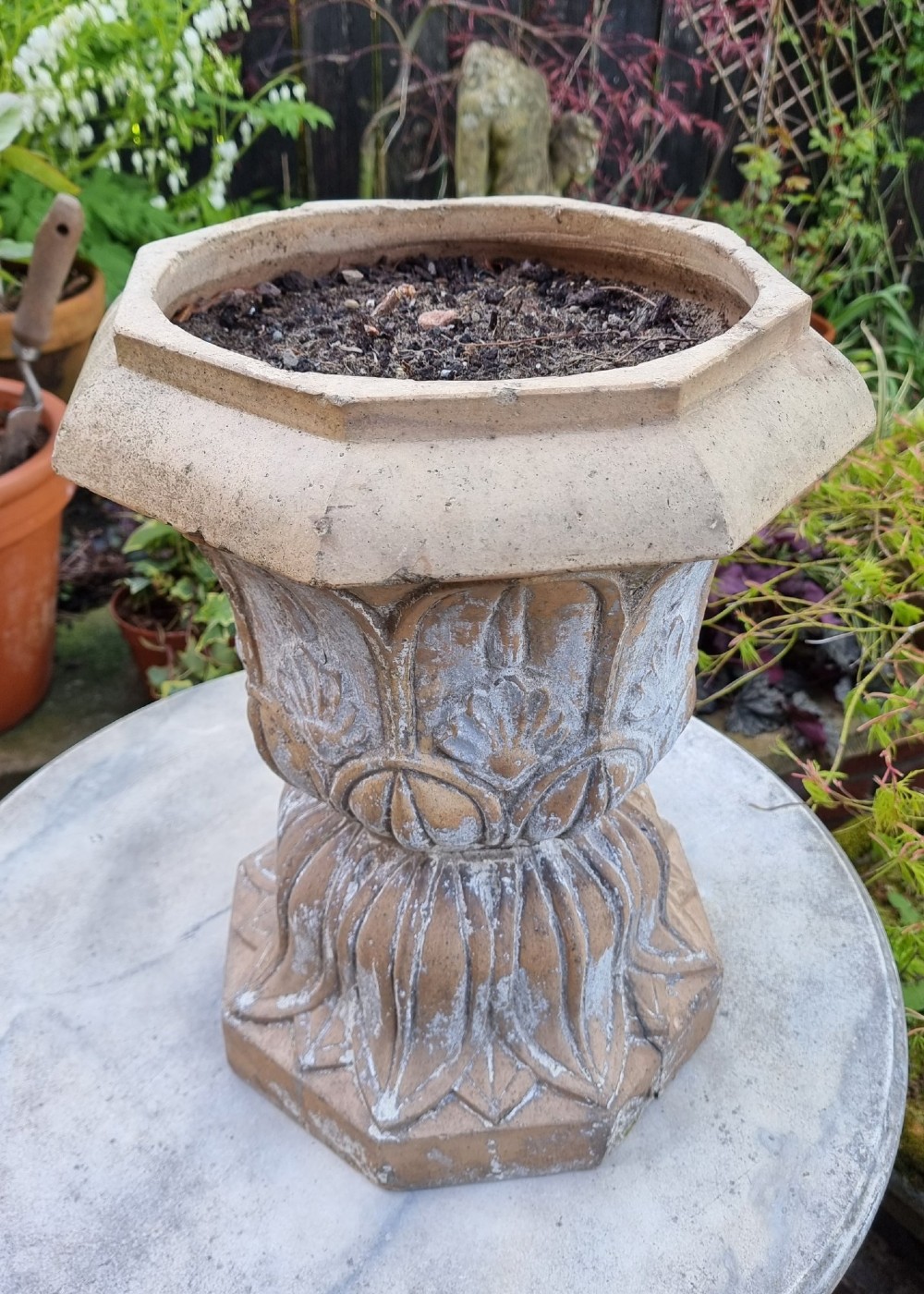 A 19th-century terracotta garden urn featuring carved leaf moulding, an octagonal top rim, and a flared pedestal base with weathered patina. View II