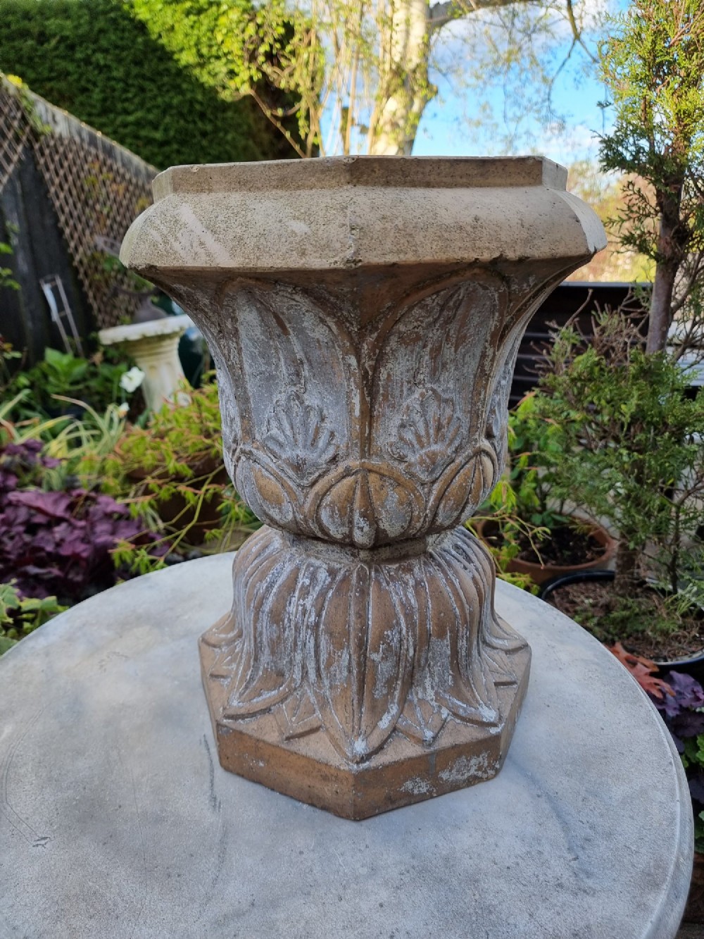 A 19th-century terracotta garden urn featuring carved leaf moulding, an octagonal top rim, and a flared pedestal base with weathered patina. View VIII