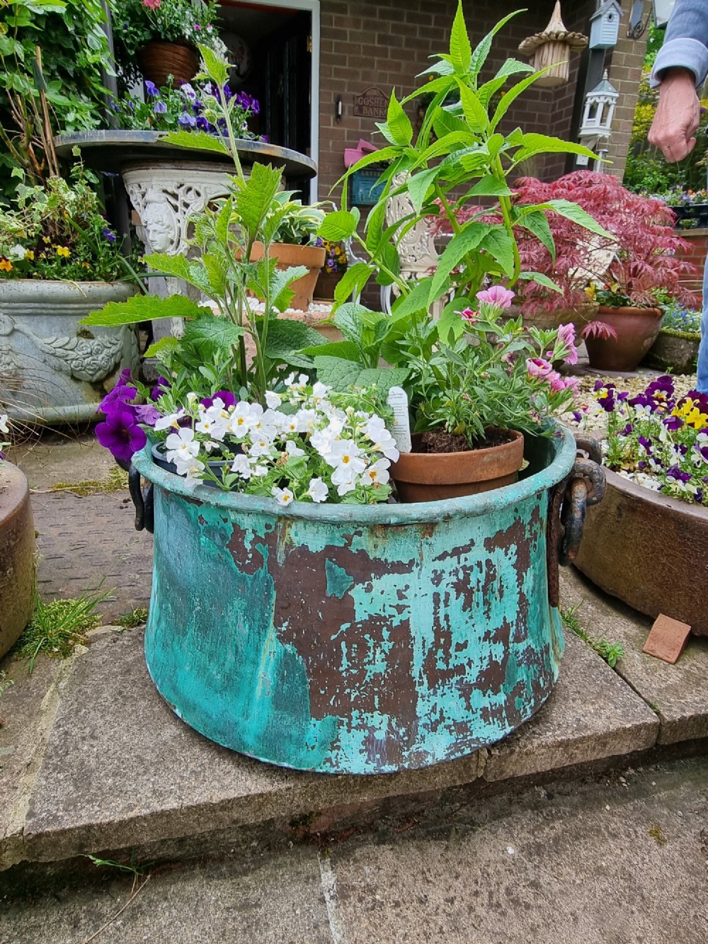 A large circular 19th-century copper vessel with a heavy verdigris green patina and dual wrought-iron drop handles. View II