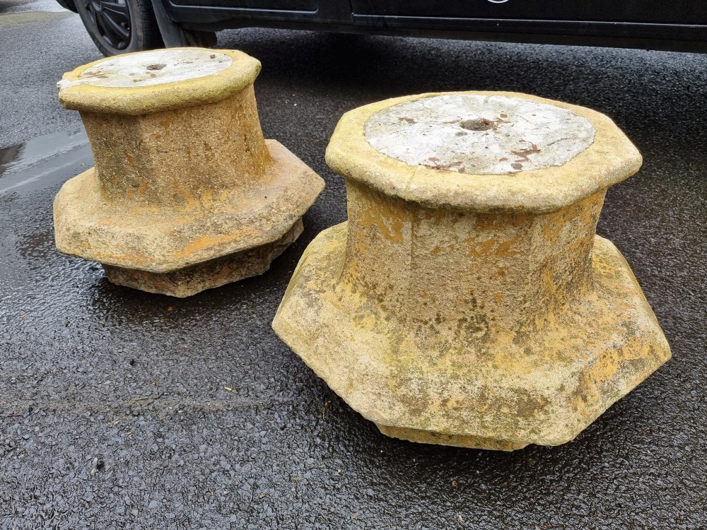 A pair of heavy octagonal composite stone garden plinths featuring moulded borders, central fixing holes, and weathered surface texture. View IV