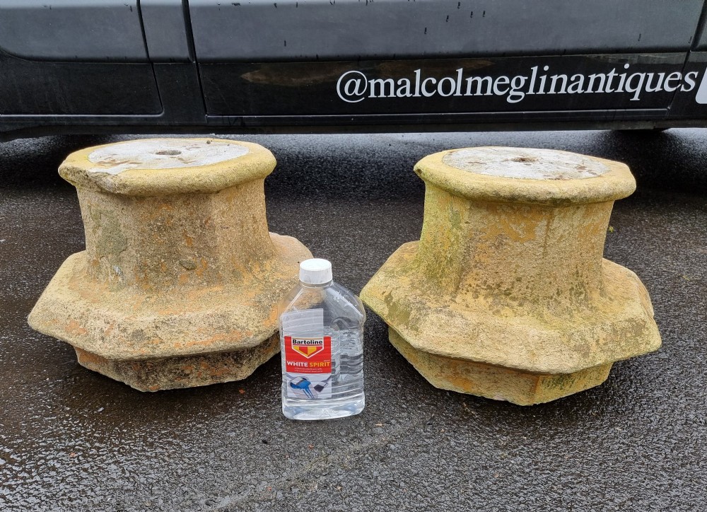 A pair of heavy octagonal composite stone garden plinths featuring moulded borders, central fixing holes, and weathered surface texture. View V