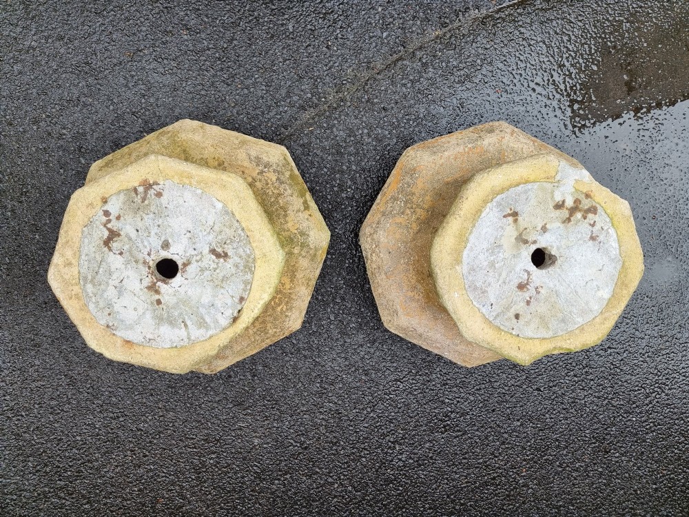 A pair of heavy octagonal composite stone garden plinths featuring moulded borders, central fixing holes, and weathered surface texture. View VI